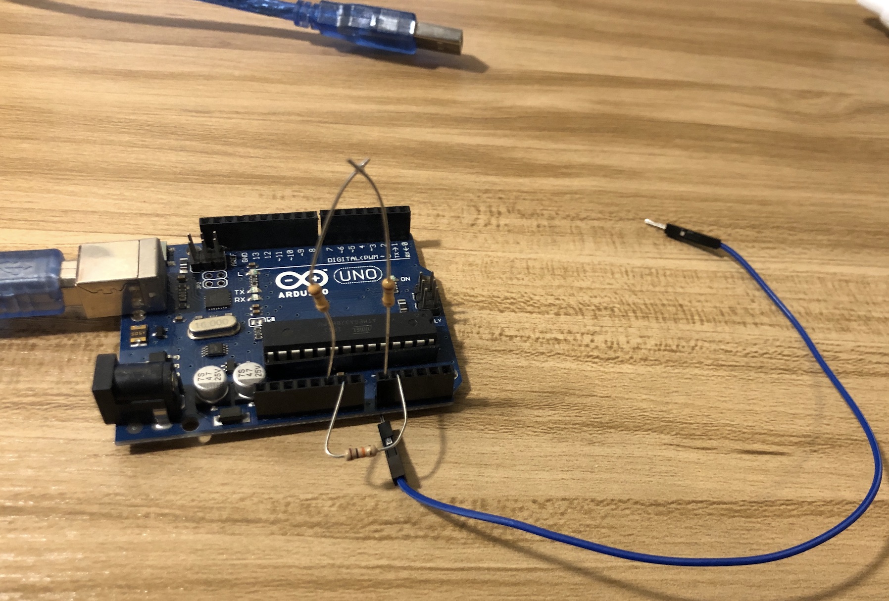 Arduino with jumper wire on analog pin, which is connected to the ground by resistor